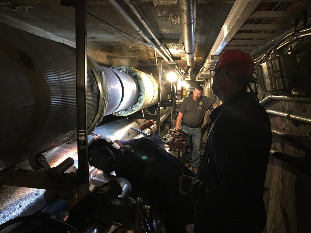 two men work inside a tunnel