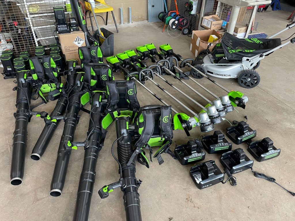 battery-powered blowers and string trimmers arrayed on the floor